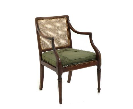 A mahogany library armchair, 19th century, the curved rail above open arms and a seat with drop in cushion, raised on ring-tu