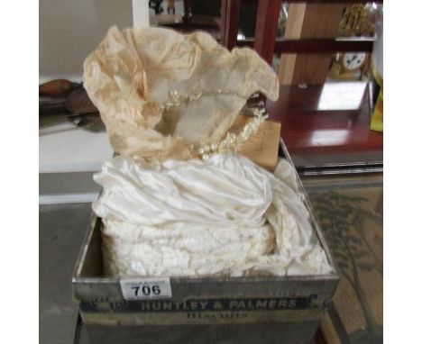 A Huntley and Palmers biscuit tin containing a vintage wedding gown.