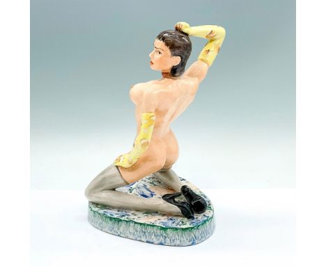 Glossy Art Deco figure of an exposed woman in a mint green hooded cloak, resting on a black floral rectangle pedestal.Glazed 