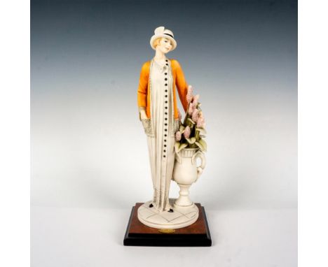 Features a sensuous delicate woman standing by purple flowers; standing on a square wooden base. Giuseppe Armani signature on