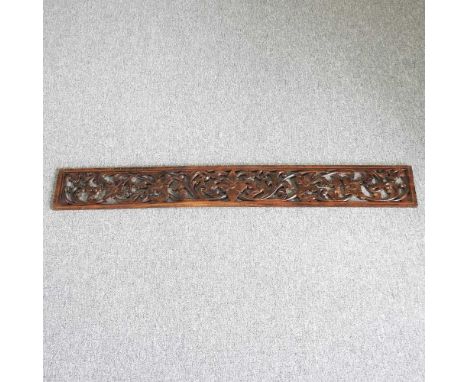 A carved walnut fretwork panel, decorated with flowers and scrolls, 19 x 150cm