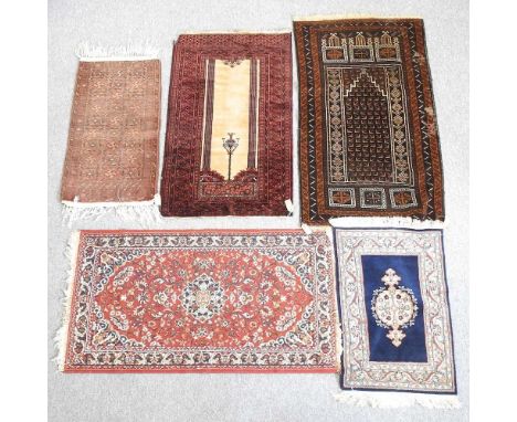 A Persian woollen prayer rug, with a central ivory panel, 132 x 77cm, together with a collection of four various rugs (5)