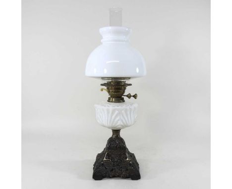 An early 20th century cast oil lamp, with an opaline glass font and shade, 53cm high