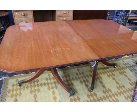 A mahogany twin pillar dining table in late George III style, 20th century, with two additional leaves, 76cm high, 114cm wide