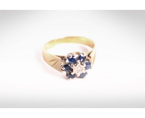 An 18ct gold diamond and sapphire flower ring. 3.8g size K