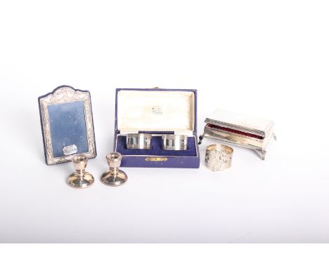 A collection of sterling silver items to include a silver mounted picture frame, a footed jewellery box with engine turned to