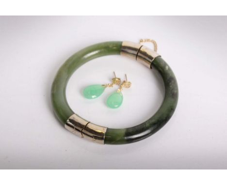 A nephrite bangle with white metal mounts together with a pair of yellow metal and jadeite drop earrings.