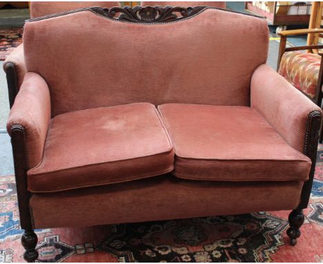 An Edwardian upholstered show wood three piece suite. Two seater sofa and two armchairs in dark pink upholstery.