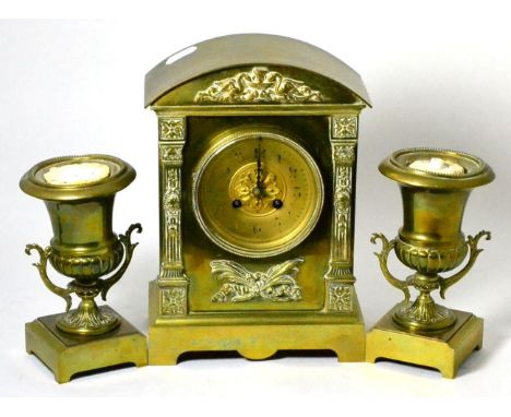 A 19th century brass clock garniture, the clock of architectural form flanked by a pair campana style urns 