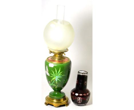 A French oil lamp, a ruby flashed carafe and basket 