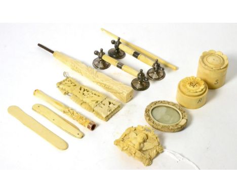 A carved ivory cruet set, a carved ivory plaque, knife rest, a cheroot holder and a parasol handle, late 19th/early 20th cent