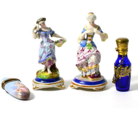A Continental silver and enamel scent flask; another enamelled glass example, and a pair of miniature bisque china figures