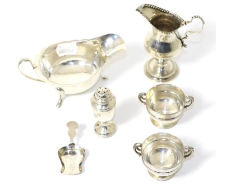 A group of silver items comprising: a caddy spoon, pepperette, sauceboat, pair of salts and a George III style cream jug, 10.