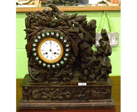 A carved oak striking mantel clock 