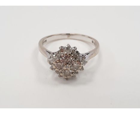 18ct white gold diamond cluster ring set with four brilliant cut diamonds within a border of further eight cut diamonds, fing