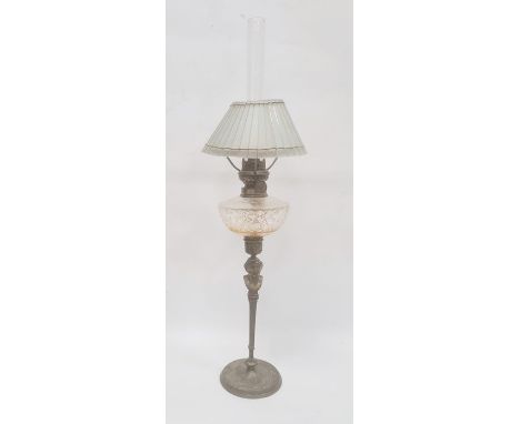 Brass and glass oil lamp having cut well, glass panelled shade, on brass mask and tapering column, ivy scroll decorated circu