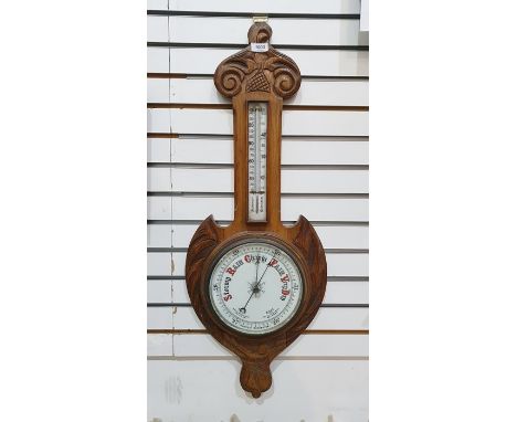 Oak aneroid barometer with scroll pediment, the enamel dial with thermometer, 82cm long overall 