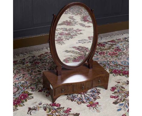 MAHOGANY UPRIGHT OVAL DRESSING GLASS OF GEORGE III DESIGN 
on a serpentine base and fitted with three drawers, on bracket fee