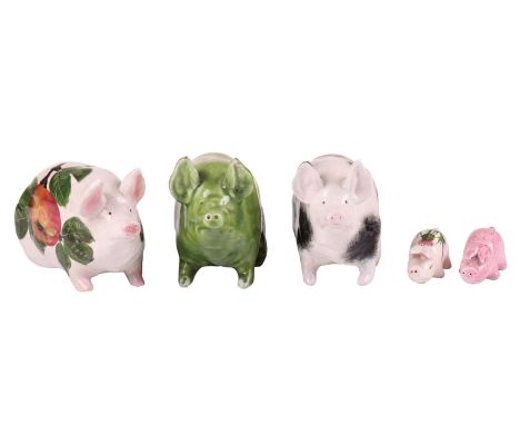 Three small Wemyss Ware pigs, in black and white, green glaze and 'Apples' pattern, 9.5 cm x 15.5 cm, together with two furth