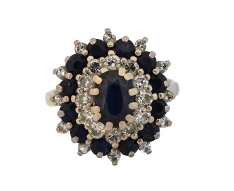 A sapphire and diamond cluster ring, A sapphire and diamond cluster ring, the oval shape sapphire within a vari cut diamond a