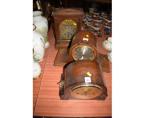 A chiming mantel clock in stained wood case with decorative turned half columns; and two further chiming mantel clocks in oak