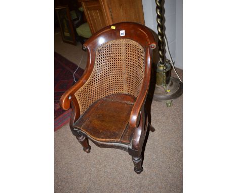 A child's 19th Century mahogany commode chair with cane back.