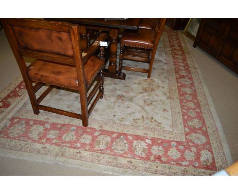 An Afghan carpet, the foliate medallions on ivory ground surrounded by a rust red palmette border; 144 x 108in.