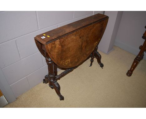 An inlaid figured walnut Sutherland table, raised on turned and carved supports, fitted white ceramic castors.