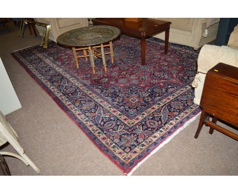 A mid 20th Century Tabriz carpet, decorated with full floral design on maroon ground with scrolling foliate border (worn).