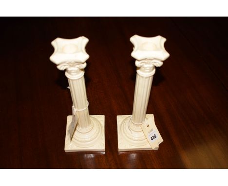 A pair of creamware style corinthian column pattern ceramic candlesticks, impressed 'England', number 1198 in the base, and v