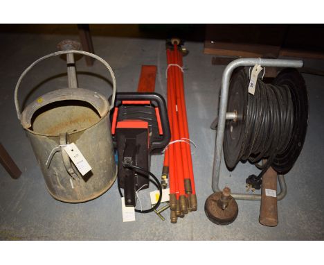 A pick axe; a set of draining rods; an electric hedge trimmer; extension cable; and a watering can.