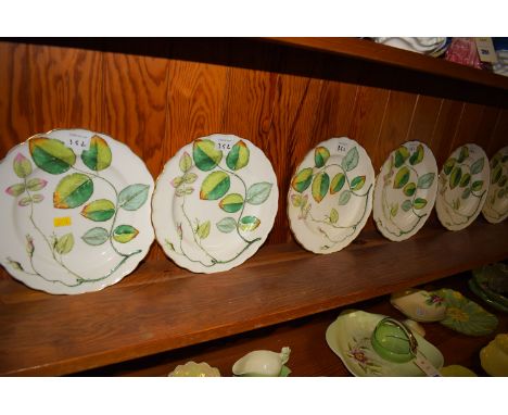 A collection of seven Continental ceramic dessert plates, with raised rosebud and foliage decoration on white ground and gild