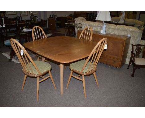 An Ercol light stained elm six-piece dining suite. 