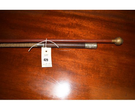 A Northumberland Hussars swagger stick covered in leather; and another swagger stick with embossed metal pommel depicting a c