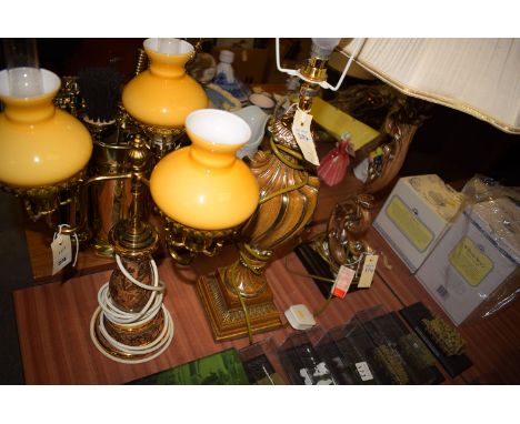 A modern scrolling table lamp with fluted cream coloured shade; another table lamp with matching shade; and a three-branch ta