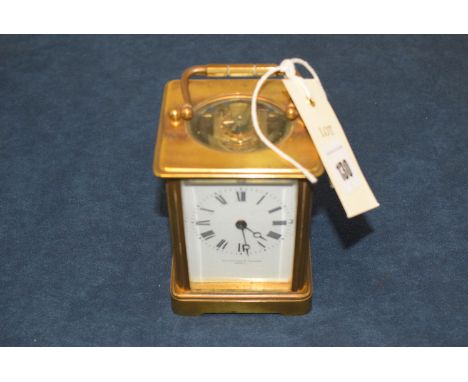 A brass carriage clock with enamel dial.