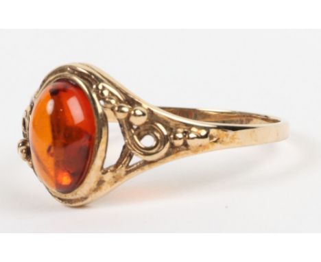 A 9ct gold and amber single stone ring, with scroll work shoulders, size N, 2.06g