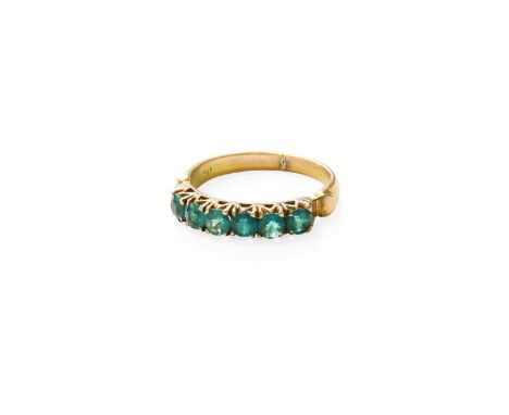 An Emerald Six Stone Ring, the round cut emeralds in yellow claw settings, to a plain polished shank, finger size JStamped '1