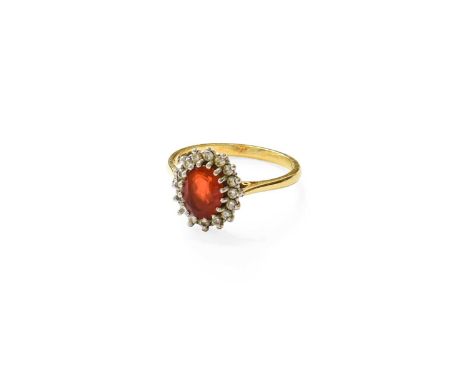 An 18 Carat Gold Fire Opal and Diamond Cluster Ring, the oval cut fire opal within a border of round brilliant cut diamonds, 