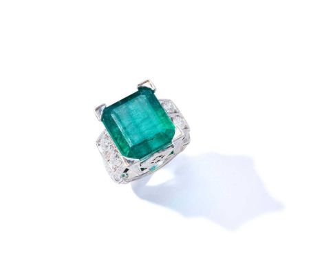 An emerald and diamond dress ring The cut-cornered step-cut emerald between brilliant-cut diamond two-stone shoulders, to an 