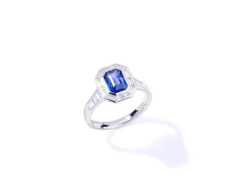 A sapphire and diamond cluster ring Collet-set with a cut-cornered rectangular step-cut sapphire, within a baguette-cut diamo