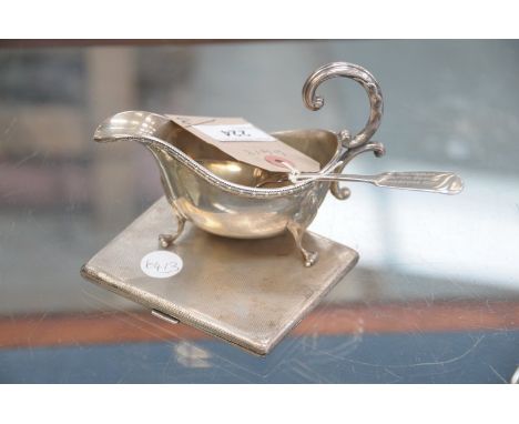 A Silver sauce boat raised on 3 paw feet, Sheffield 1930, an engine turned silver cigarette case , London 1950 and a silver t