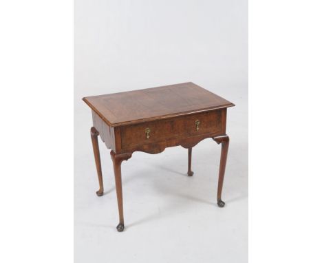 A walnut and herringbone crossbanded side table
The rectangular moulded top with a herringbone inlaid border above a frieze d