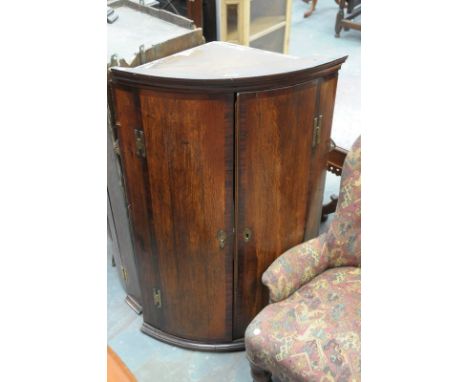 A 19th Century oak and mahogany cross banded bow front hanging 2 door corner cupboard.