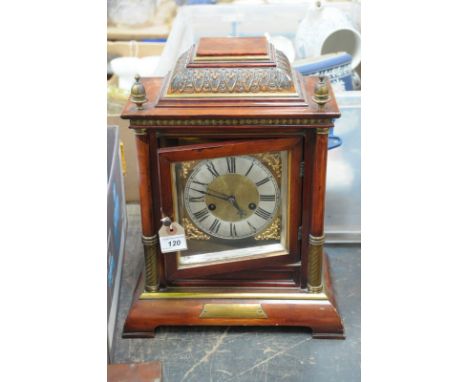 A simulated walnut cased mantle clock early 20th Century
With a 13cm silvered dial with Roman numerals, leafy spandrels the t