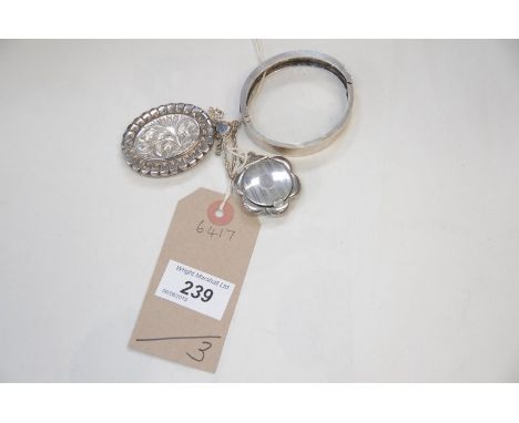 A Hallmarked silver open work bangle ,  a silver oval pendant locket, a shaped silver locket and chain and a silver sixpence.