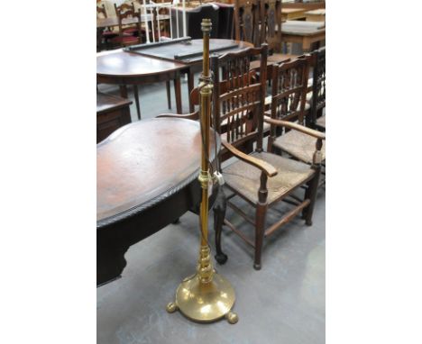 A brass telescopic standard lamp, 20th Century
The circular bell shape base with compressed bun feet rising to a baluster cyl