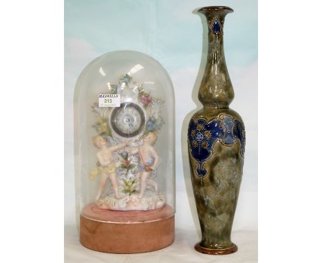 A Dresden style china mantel clock with cherub and encrusted decoration, under glass dome; a Royal Doulton tall stoneware vas