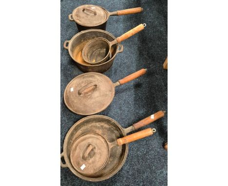 A collection of antique cast metal French cooking pots &amp; pans