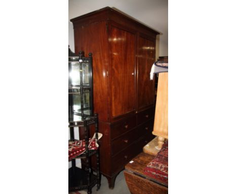 An early 19th Century mahogany linen press, the upper section enclosed two panelled door, base fitted two short and two long 